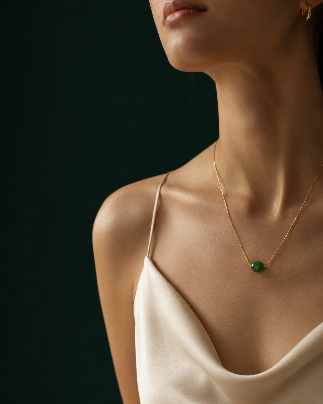Woman wearing a dainty gold plated bead necklace and small gold earrings