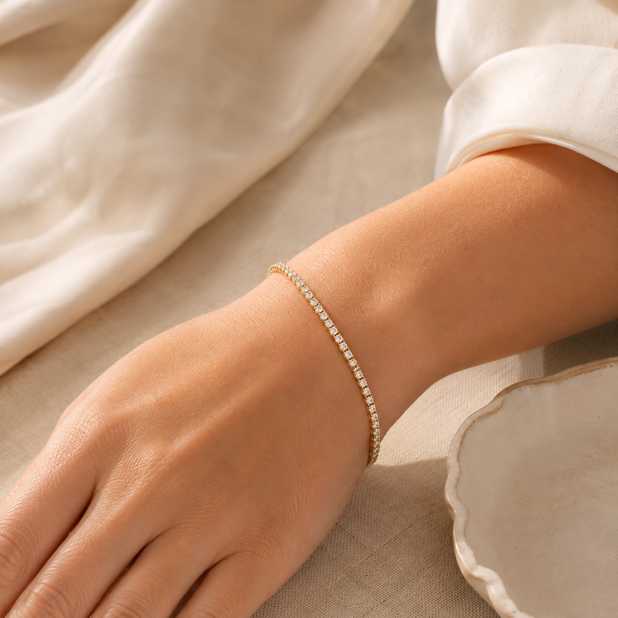 Woman wearing a 2mm CZ tennis bracelet in 18K gold-plated finish