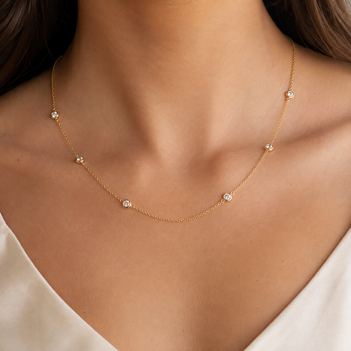 Woman wearing a delicate gold-plated cubic zirconia station necklace